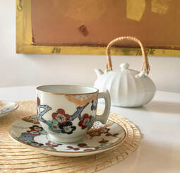 Japanese tea cup and tea pot on straw placemat