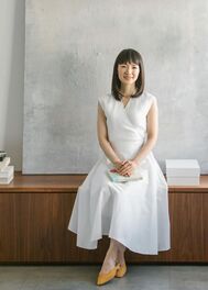 Decluttering Guru and our trainer, Marie Kondo, wearing white linen dress and seated in a minimalist room.